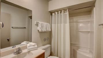 Baño con lavabo, espejo, inodoro y cortina de ducha.