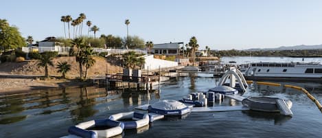 A marina with boats, a dock, and a building with a white roof.