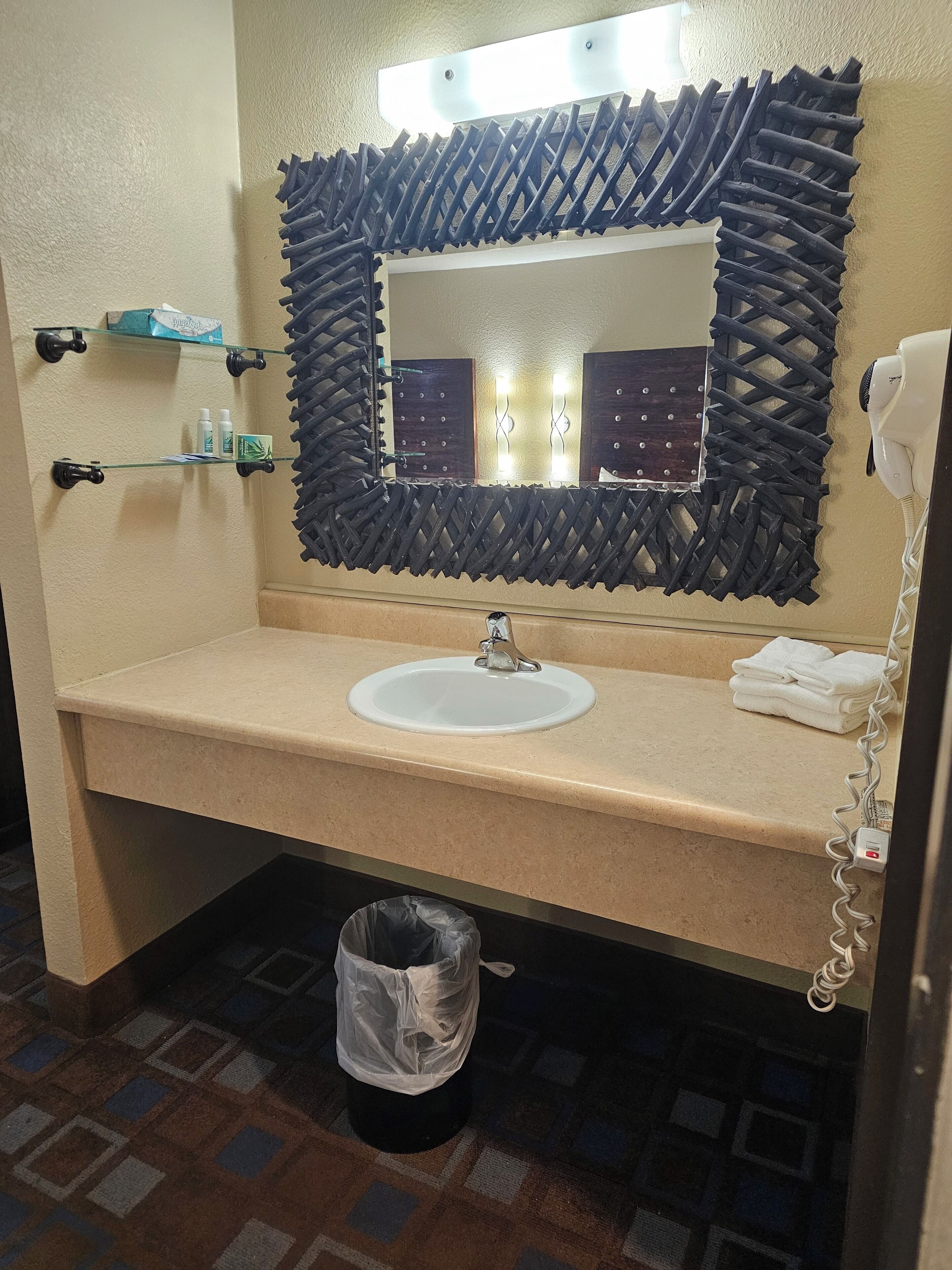 Une salle de bain équipée d’un lavabo, d’un miroir et d’articles de toilette.