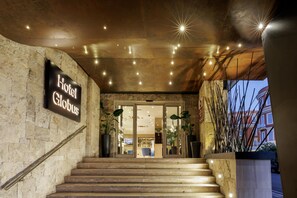 A hotel entrance with a staircase leading to the lobby, a sign reading 'Hotel Globus', and a modern ceiling design with star-like lights. - Best Western Plus Globus Hotel (Rome)