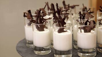 Dessert cups with chocolate shavings on a slate serving tray.