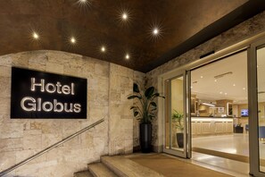 A hotel entrance with a stone facade, a staircase, and a reception area. - Best Western Plus Globus Hotel (Rome)