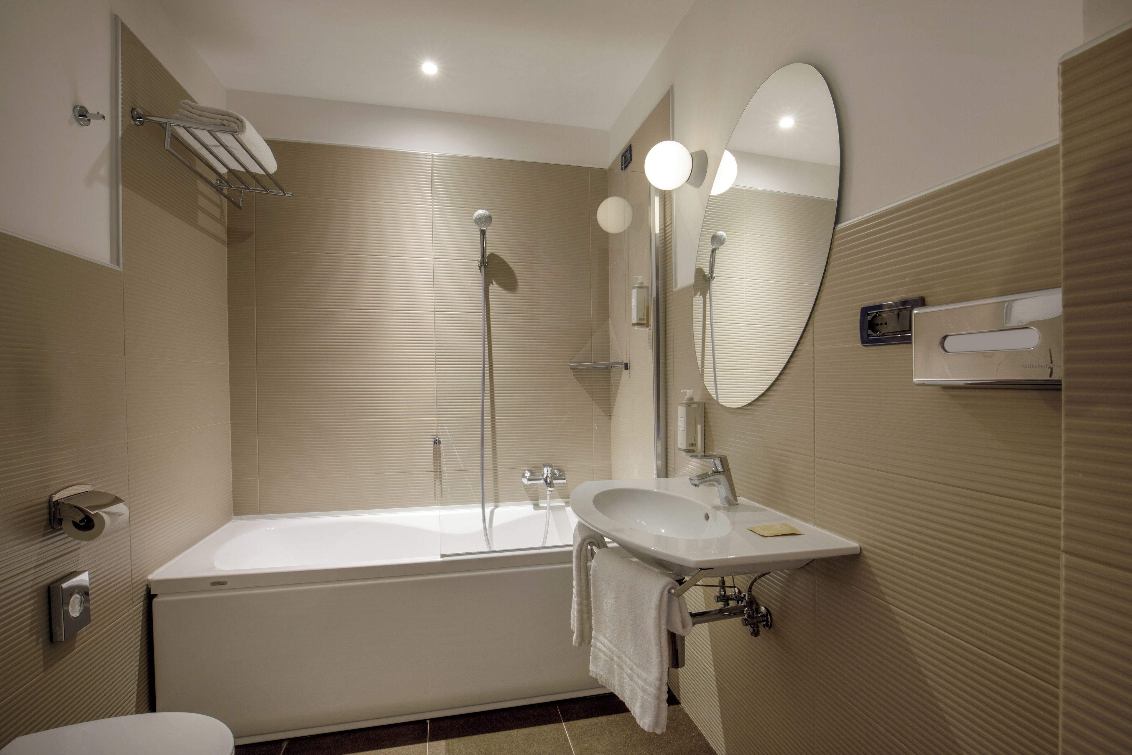 A modern bathroom with a bathtub, sink, and mirror.