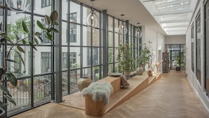 A spacious interior with large windows, wooden flooring, and modern pendant lighting. - Hotel Kong Arthur (Copenhagen)
