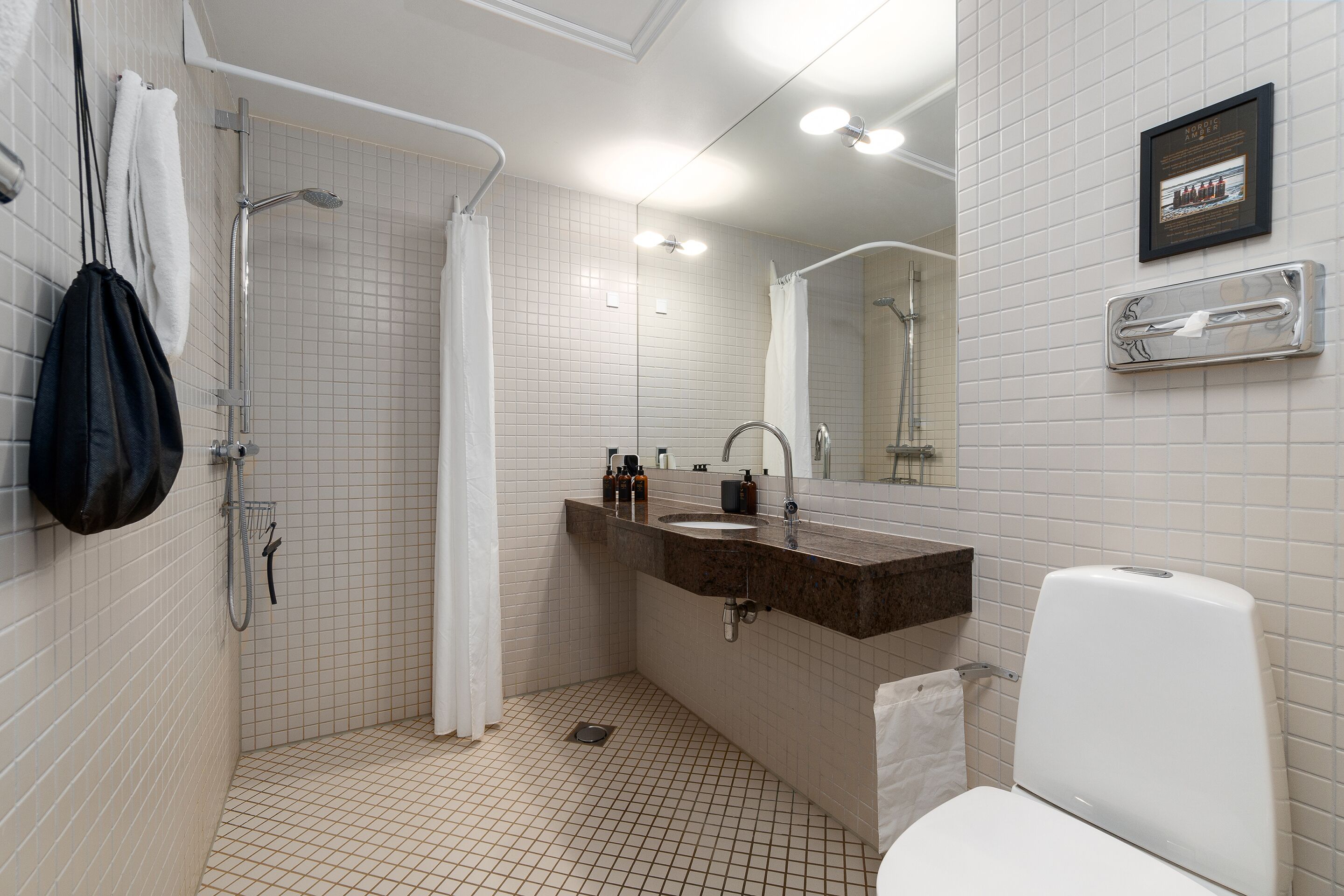A bathroom with a shower, sink, and toilet.