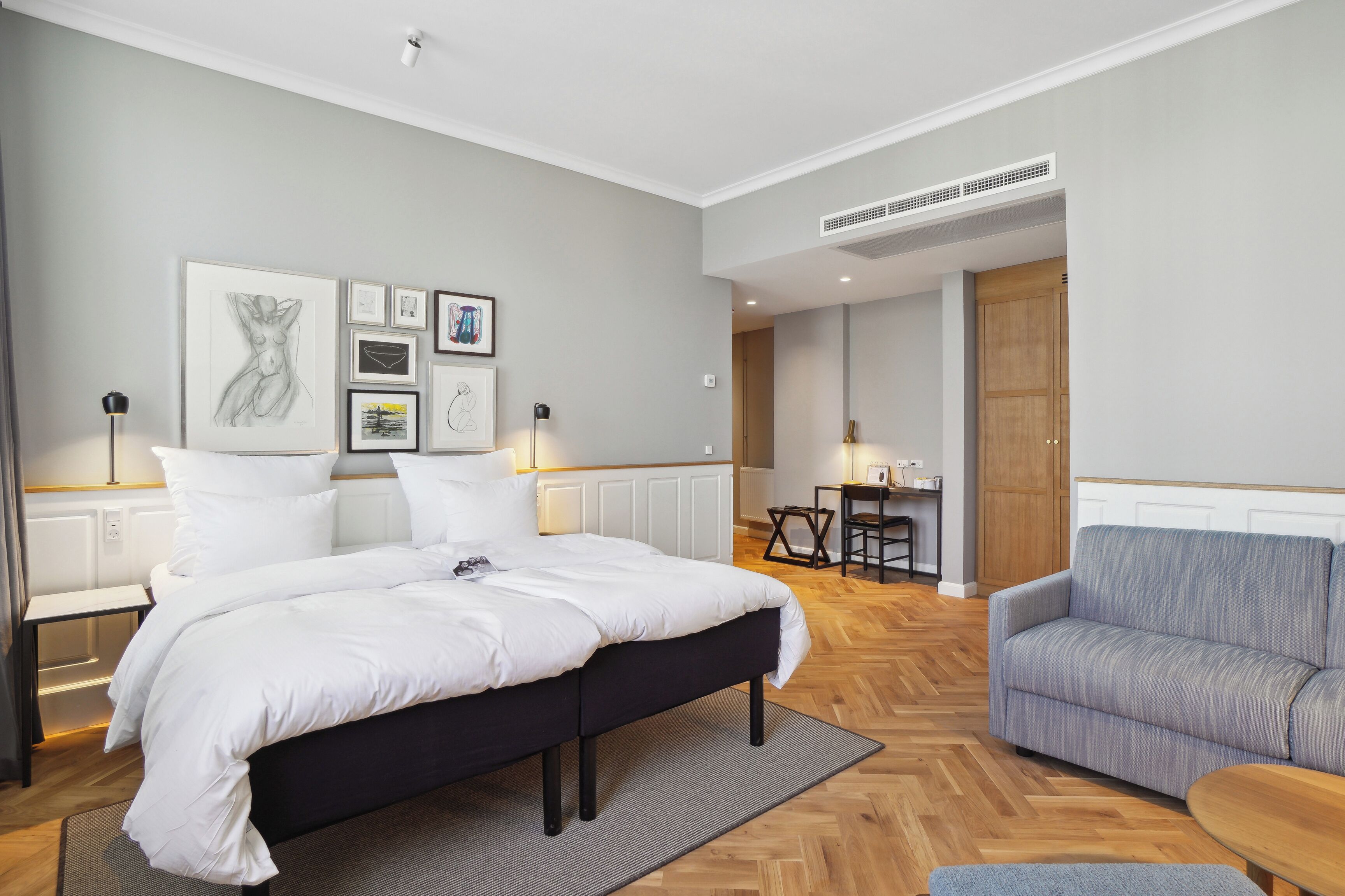Un dormitorio moderno con una cama grande, un sofá y una zona de comedor.