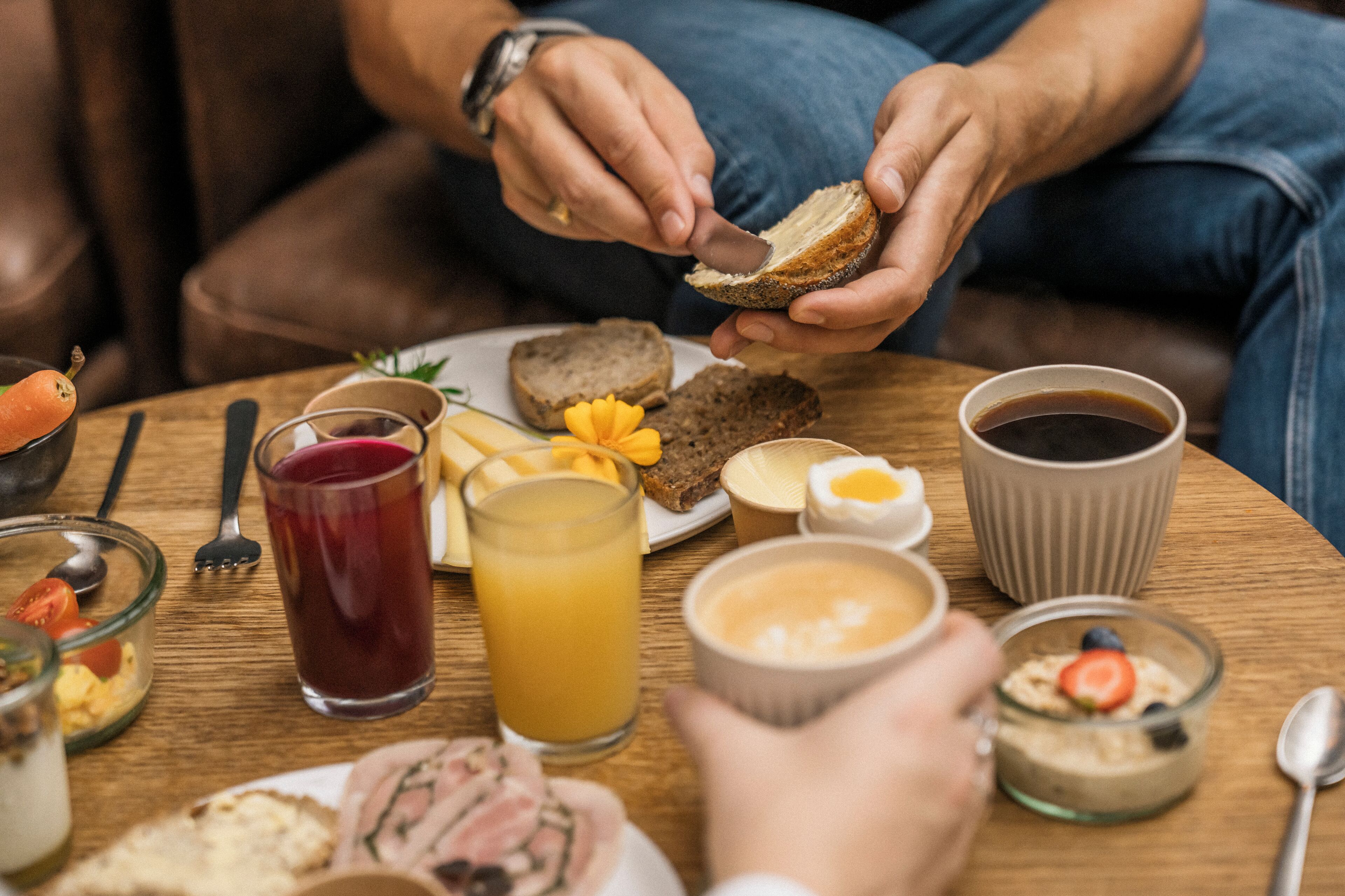 Una escena de desayuno con diversos alimentos y bebidas sobre una mesa de madera.