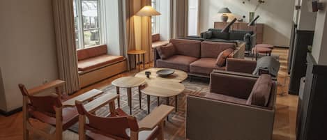 Ein modernes Wohnzimmer mit einer Sofagarnitur, einem Couchtisch und einem Fernseher.