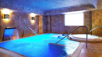 Relax by the pool surrounded by a tiled floor and walls, with a window offering a view of the surrounding area.
