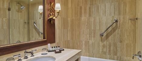 Un baño con lavamanos doble, un espejo grande, ducha con cabezal de ducha manual y bañera.