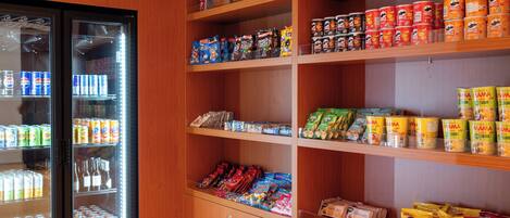 A snack and beverage vending area with various products including canned goods, snacks, and beverages.