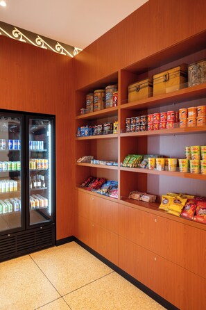 A snack and beverage vending area with various products including canned goods, snacks, and beverages. - Hotel Theater Figi (Zeist)