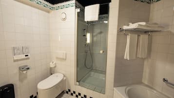 Een badkamer met toilet, douchecabine en bad.