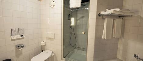 A bathroom with a toilet, a glass-enclosed shower, and a bathtub.