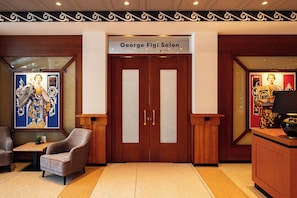 A hotel entrance with a double door, a reception desk, and a chair. - Hotel Theater Figi (Zeist)