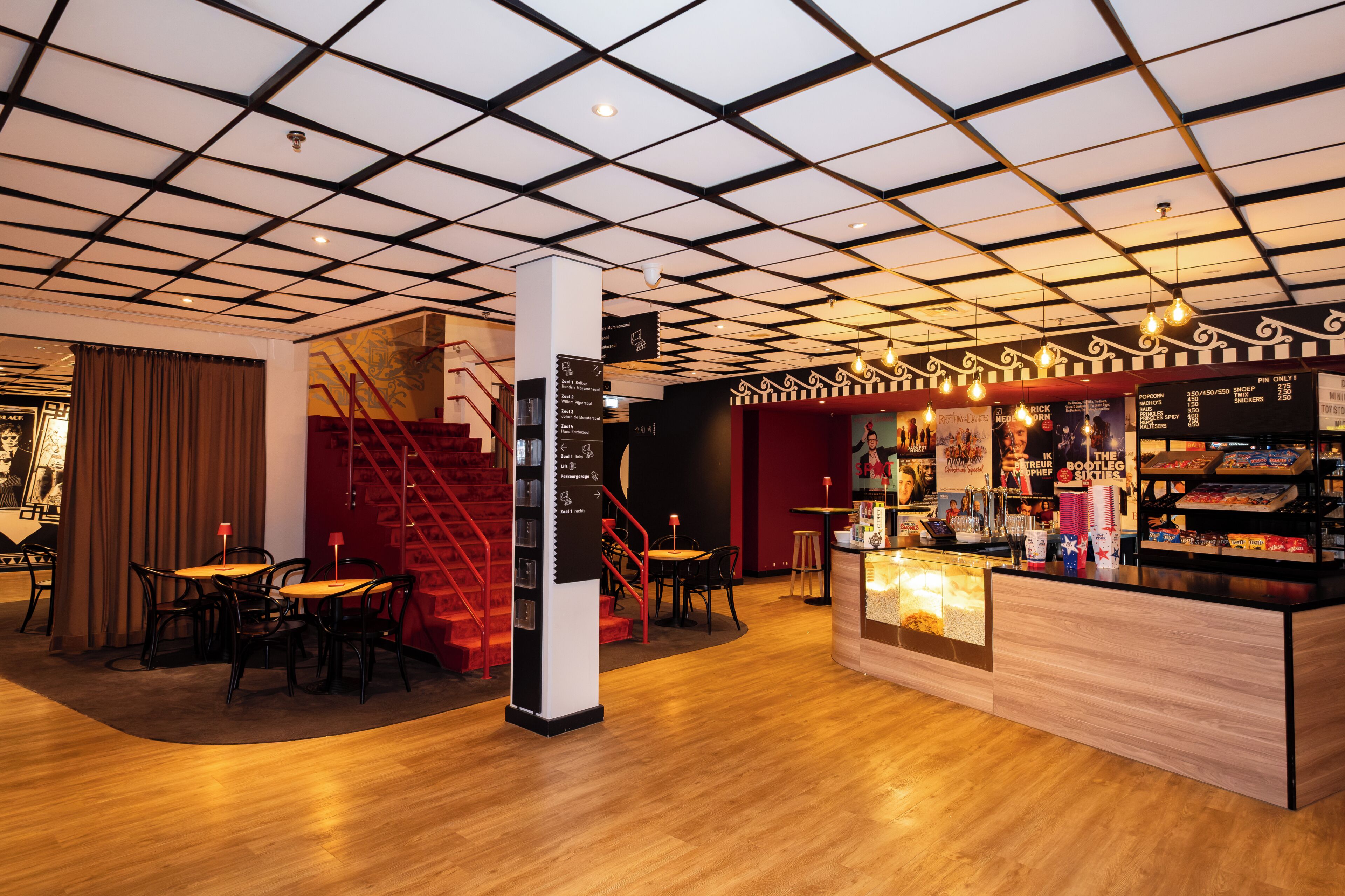 Een modern interieur met een houten vloer, een trap en een bar met snacks.