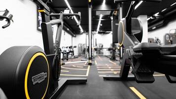 A gym with various exercise equipment, including a treadmill and weight machines.