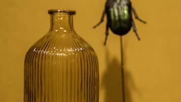 A clear glass vase with ribbed texture on a wooden surface against a yellow background.