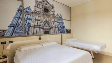 Una habitación de hotel con una cama grande, una cama más pequeña, una mesita de noche y un televisor montado en la pared.