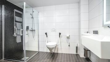 A modern bathroom with a shower, toilet, and sink.