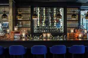 A bar area with a wine rack, bar stools, and pendant lighting. - Thon Hotel Rosenkrantz (Oslo)