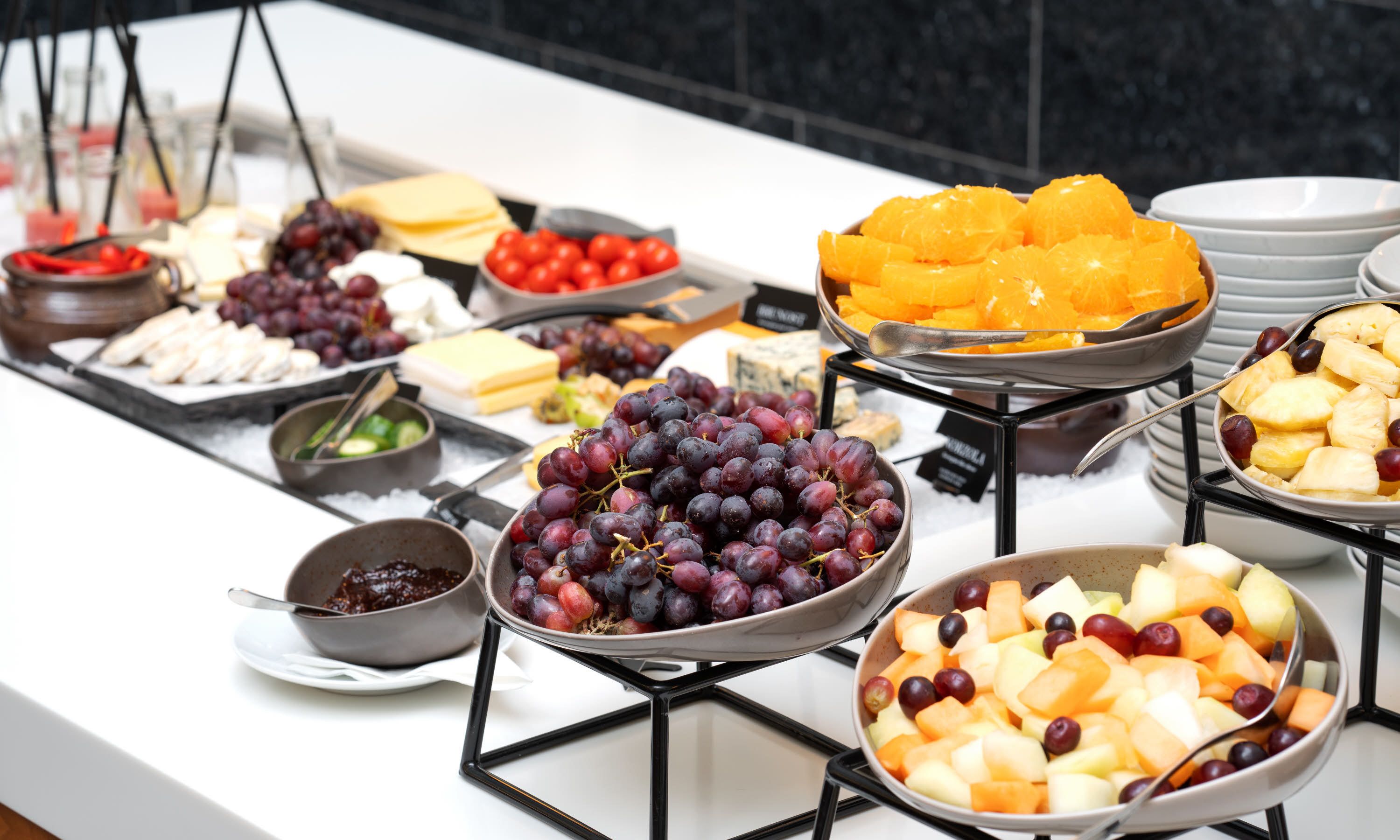 A buffet with various fruits, cheeses, and other food items.