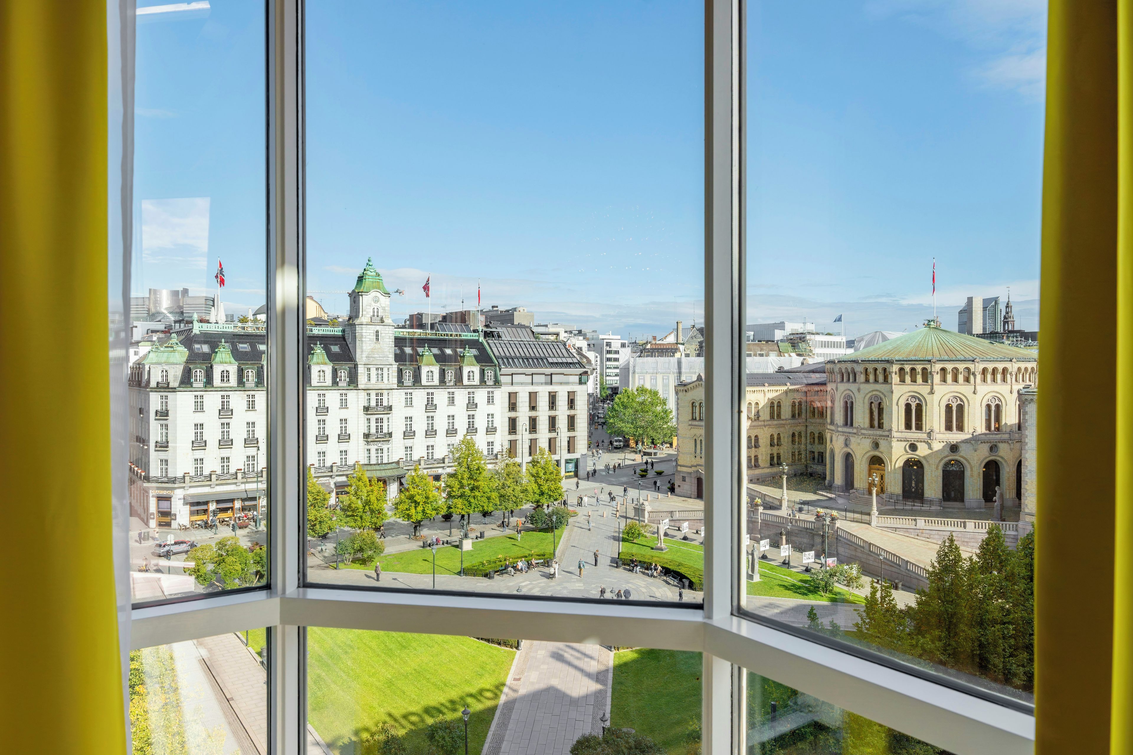 Vista des d'una finestra sobre una ciutat amb edificis històrics i una plaça central.