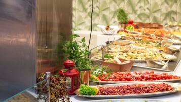 A buffet with various food items and a decorative plant.