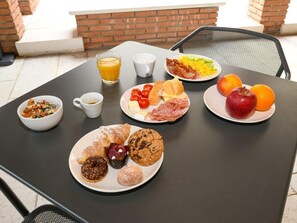 Een ontbijttafel met diverse soorten eten en een glas sinaasappelsap.
