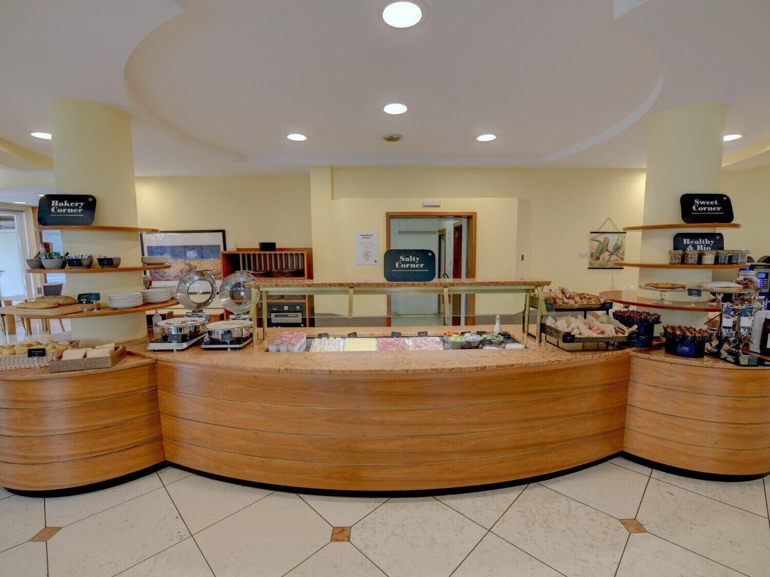 A bakery counter with various baked goods and a coffee station.