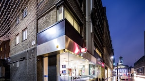 Un edificio moderno con fachada de vidrio y un cartel que dice 'LIGHT MEALS'.