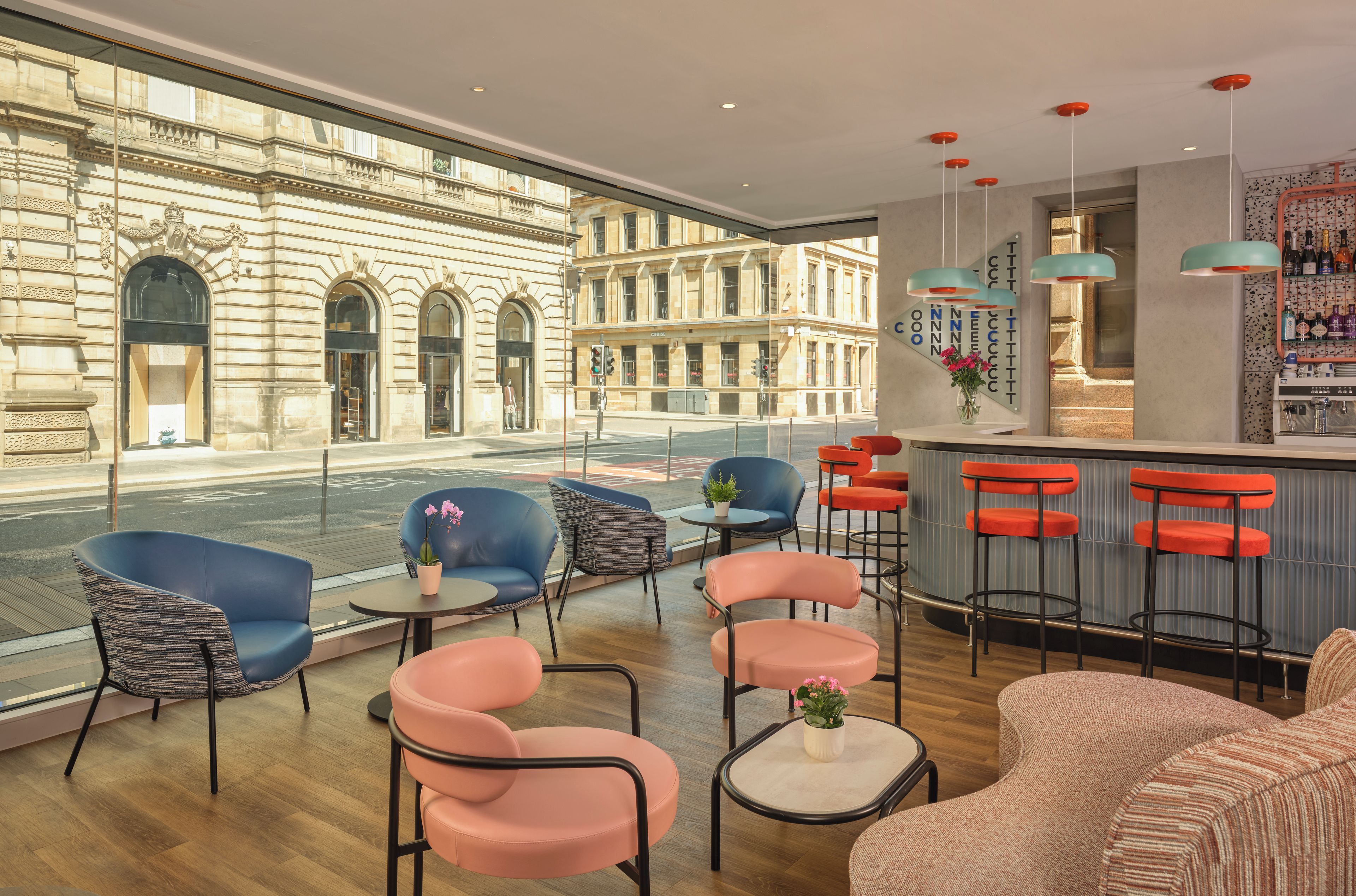 A modern interior with seating, a bar area, and a view of a historic building.