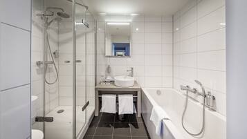 A modern bathroom with a glass-enclosed shower, a white sink, and a bathtub.