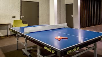 Enjoy a game of ping pong in our indoor recreation area, featuring a table and seating for a fun match.
