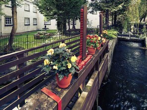 A bridge with a railing, a water channel, and potted plants with flowers. - Mercure Perth Hotel (Perth)