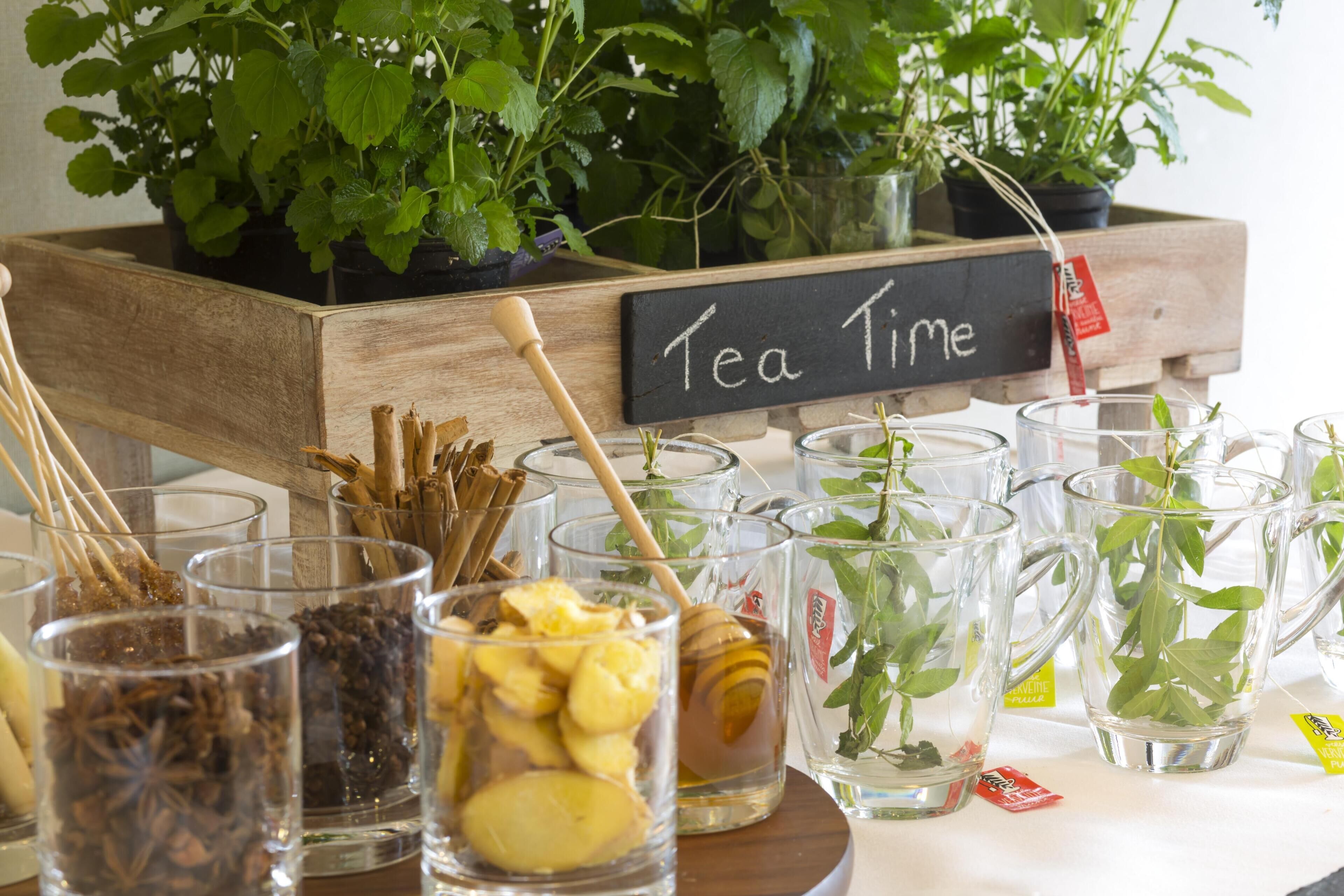 Una estación de té con diferentes infusiones y un letrero que dice 'Tea Time'.