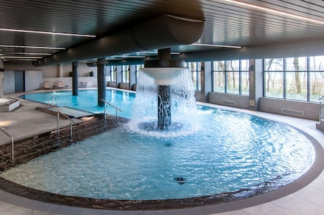 Una piscina techada, sillones reclinables de piscina