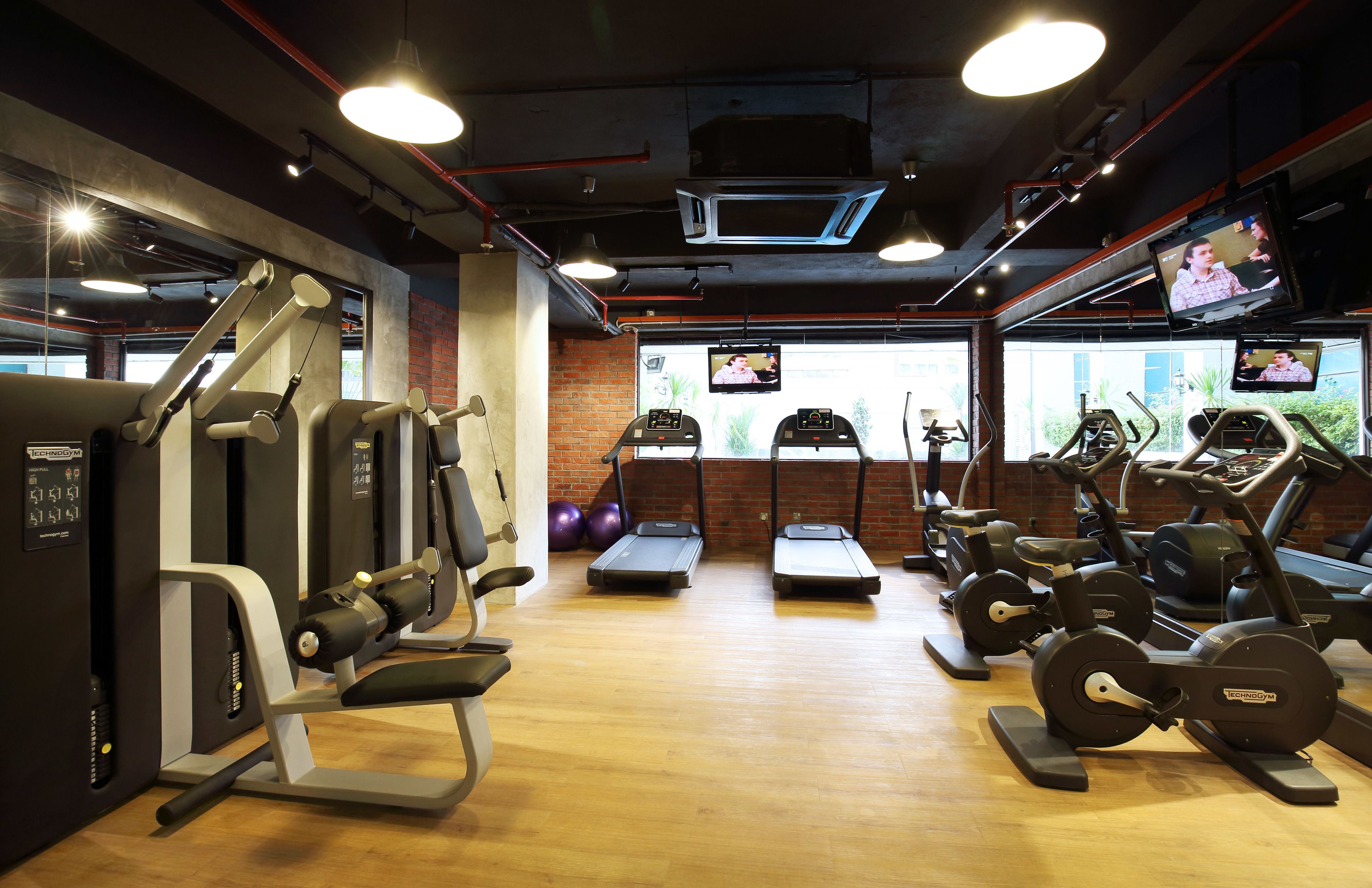 A gym with treadmills, elliptical machines, and weight equipment.