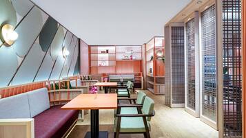 A modern interior with seating, tables, and decorative shelving.