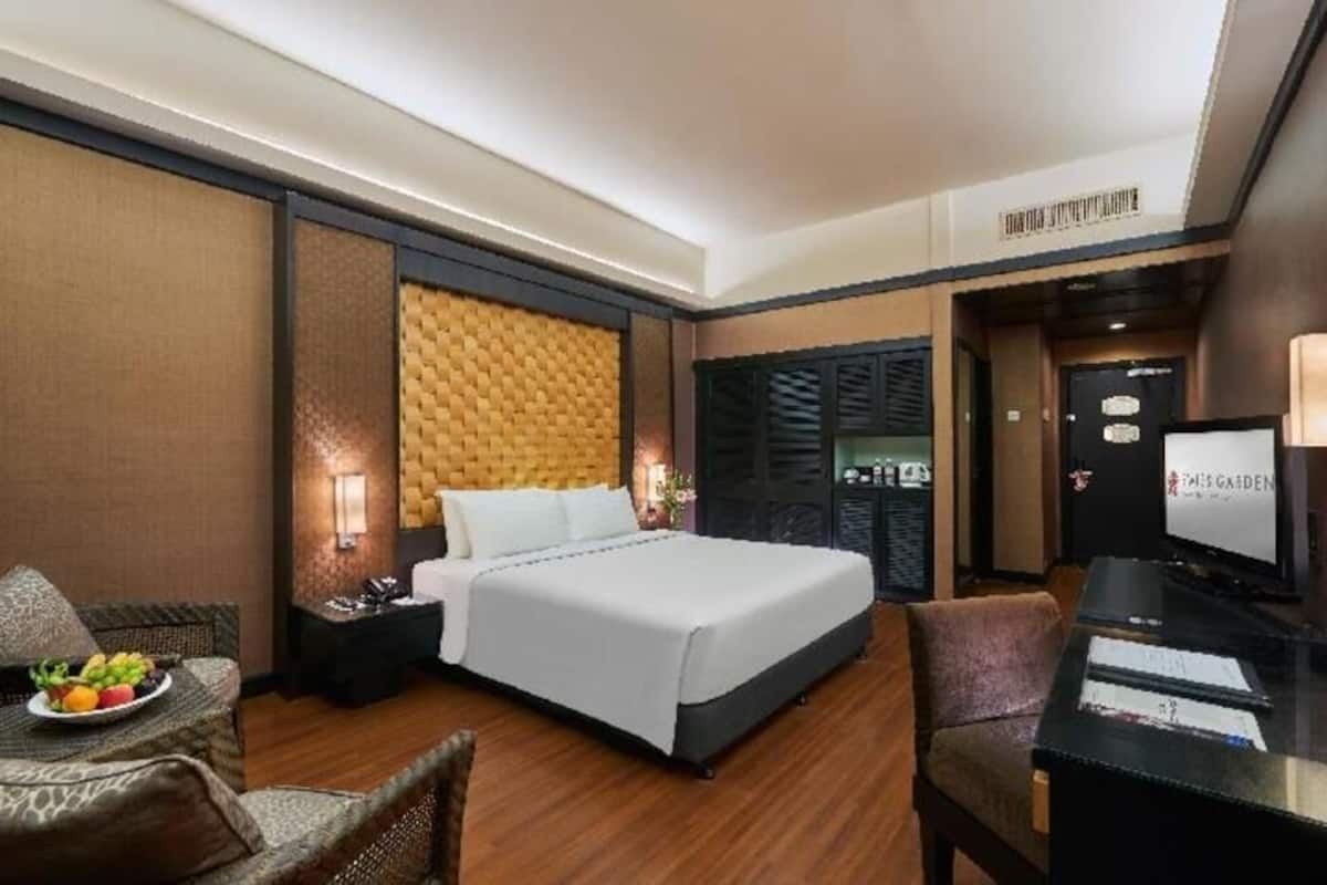 Ein Hotelzimmer mit einem Bett, einem Schreibtisch, einem Stuhl und einem kleinen Tisch mit Früchten.