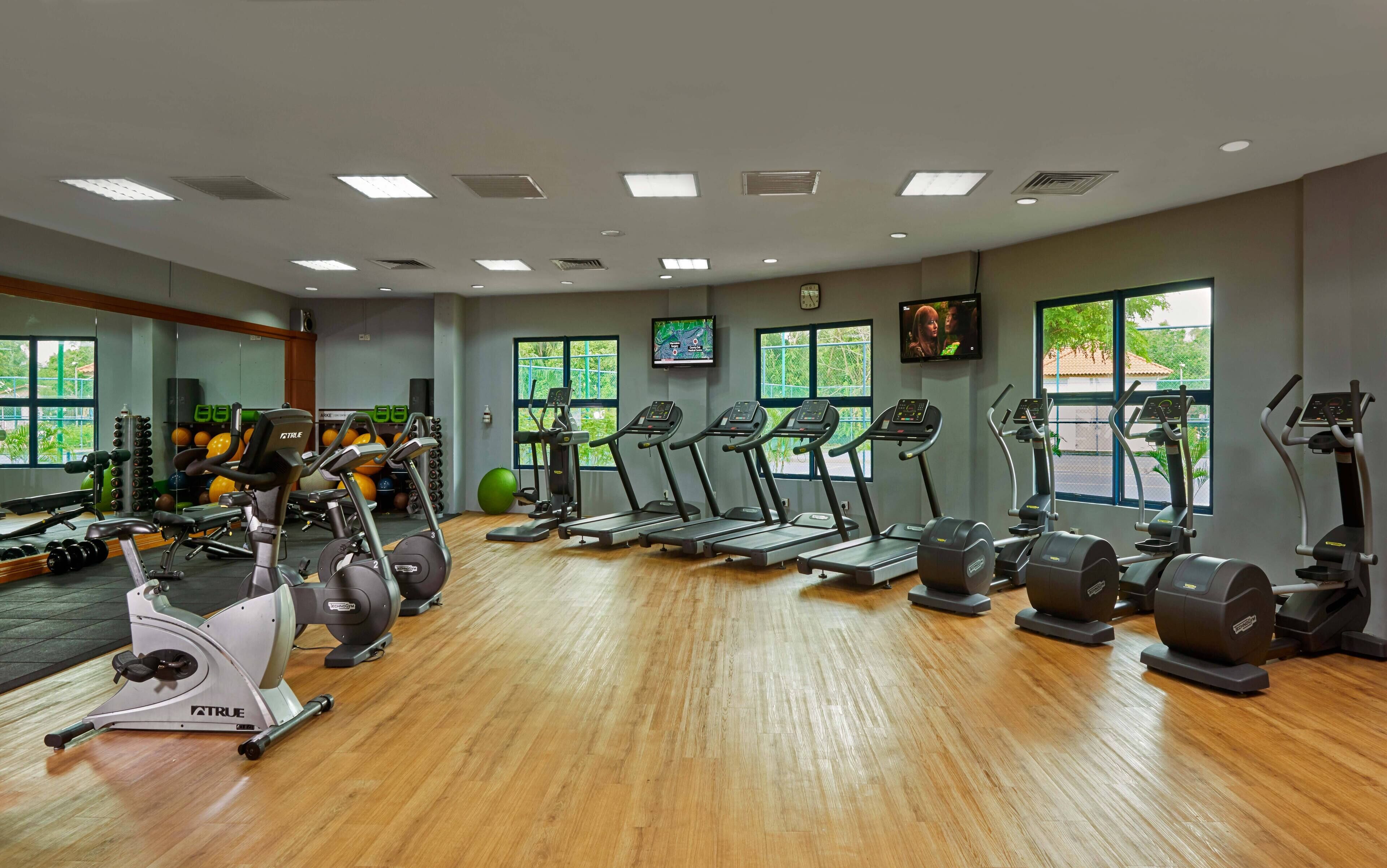 Ein Fitnessstudio mit Laufbändern, Crosstrainern und Kurzhanteln.