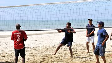 Partido de voleibol de playa con jugadores con ropa deportiva casual.