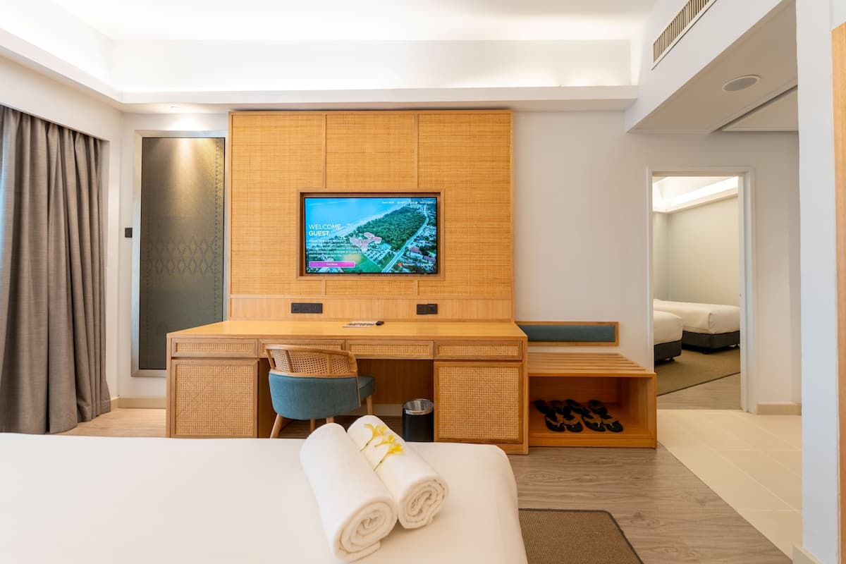 Ein Hotelzimmer mit Bett, Schreibtisch, Fernseher und Schuhablage.