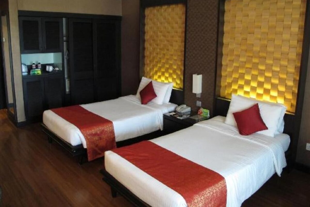 A hotel room with two beds, a desk, and a minibar.