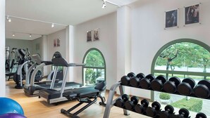 Une salle de sport équipée de tapis de course, d’haltères et de ballons d’exercice.
