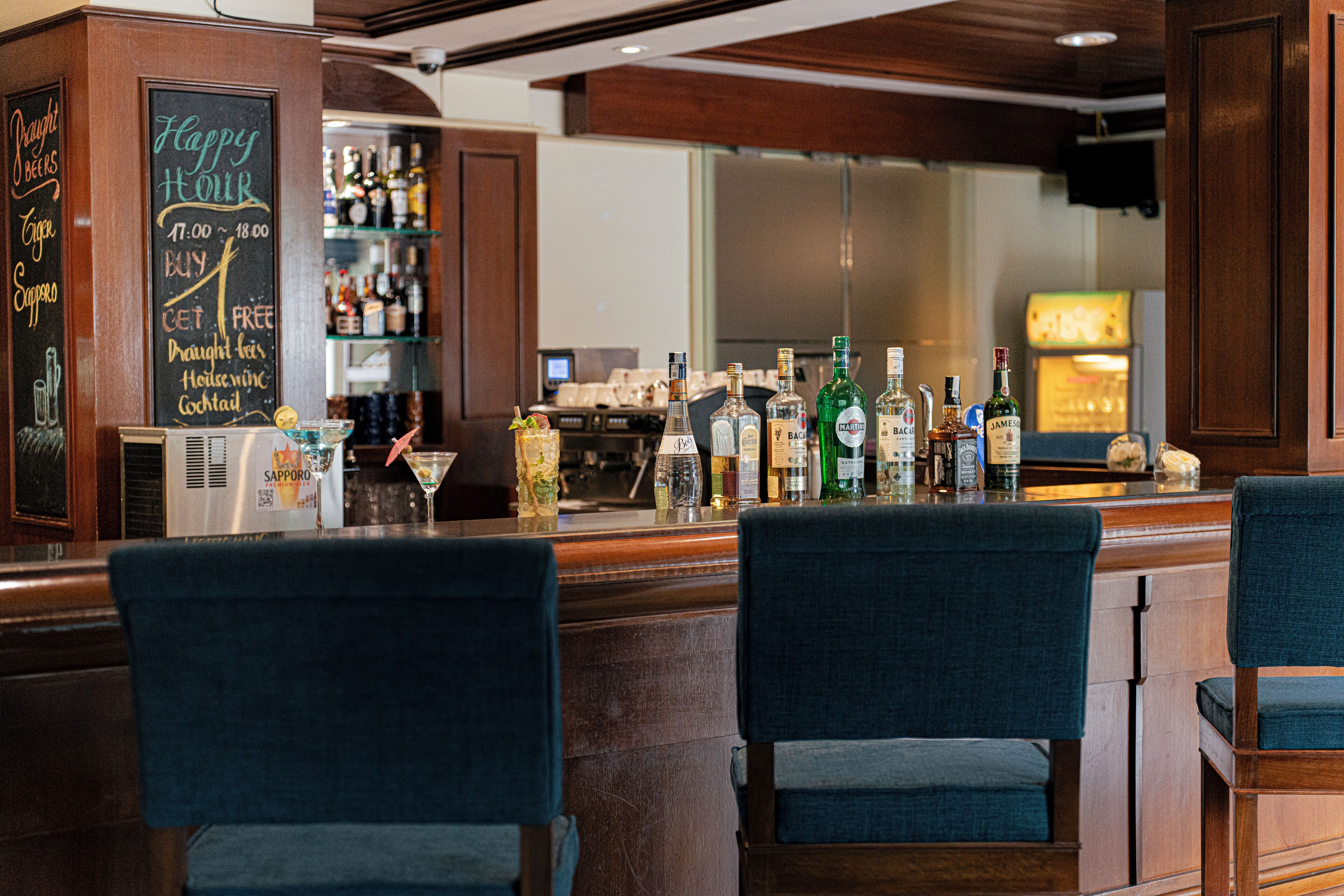 A bar area with wooden furniture, a chalkboard menu, and various bottles of alcohol.