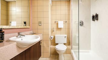 A modern bathroom with a sink, toilet, and glass-enclosed shower.