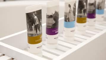 Une rangée de produits de toilette sur une étagère blanche.