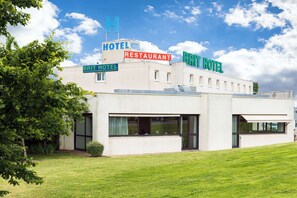 A building with signs for a hotel, restaurant, and a Brit Hotel.