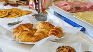 En frukostbuffé med croissanter, ägg och olika sorters pålägg.